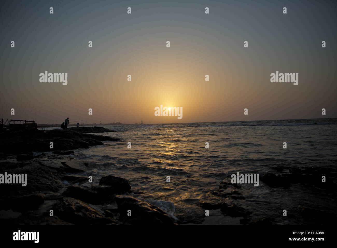 The fisherman fishes in the sea . Beautiful sunset at the beach ...