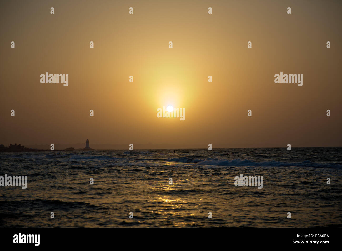 The fisherman fishes in the sea . Beautiful sunset at the beach ...