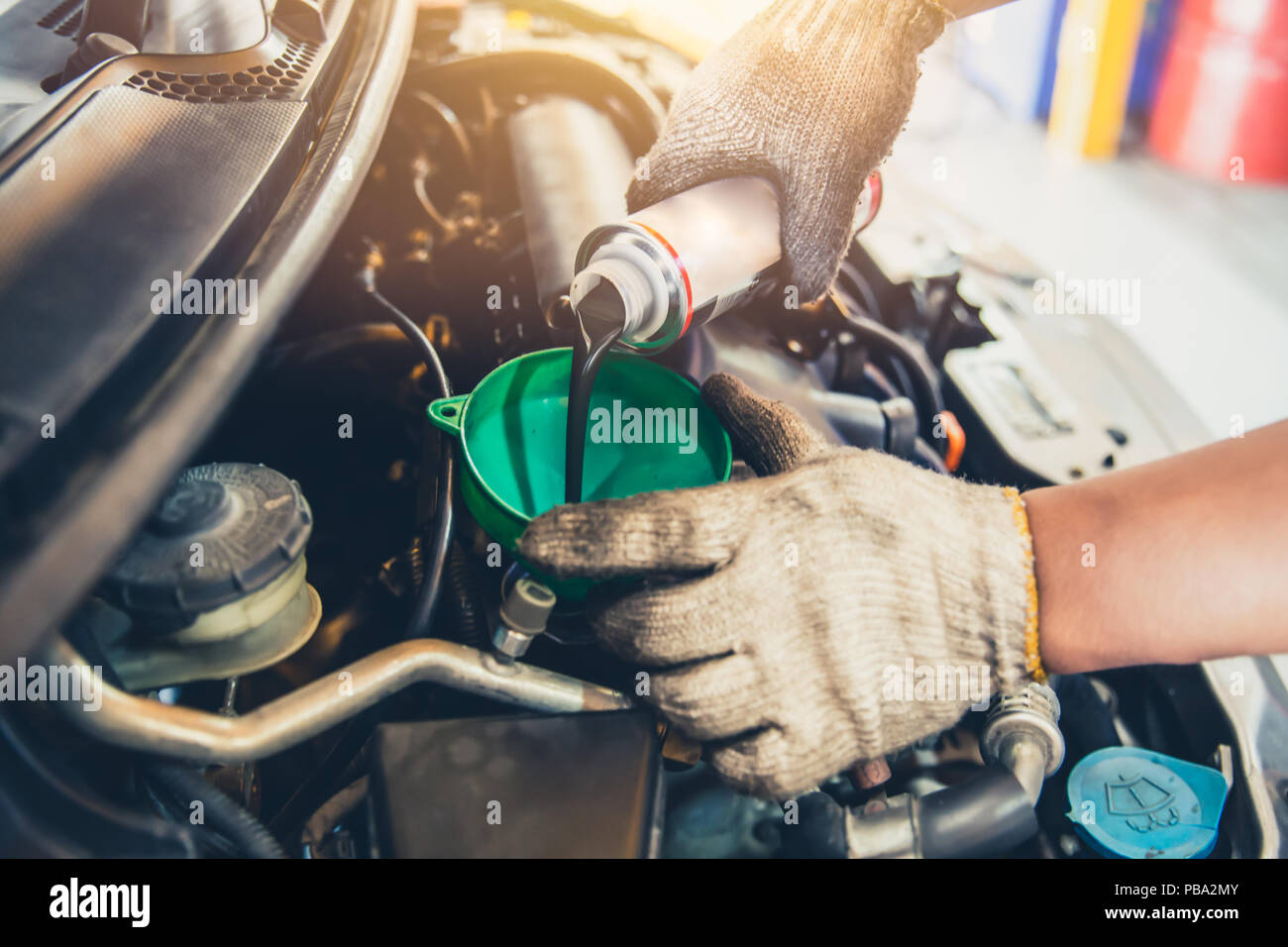 Car maintenance change oil and filling engine lube liquid Stock Photo