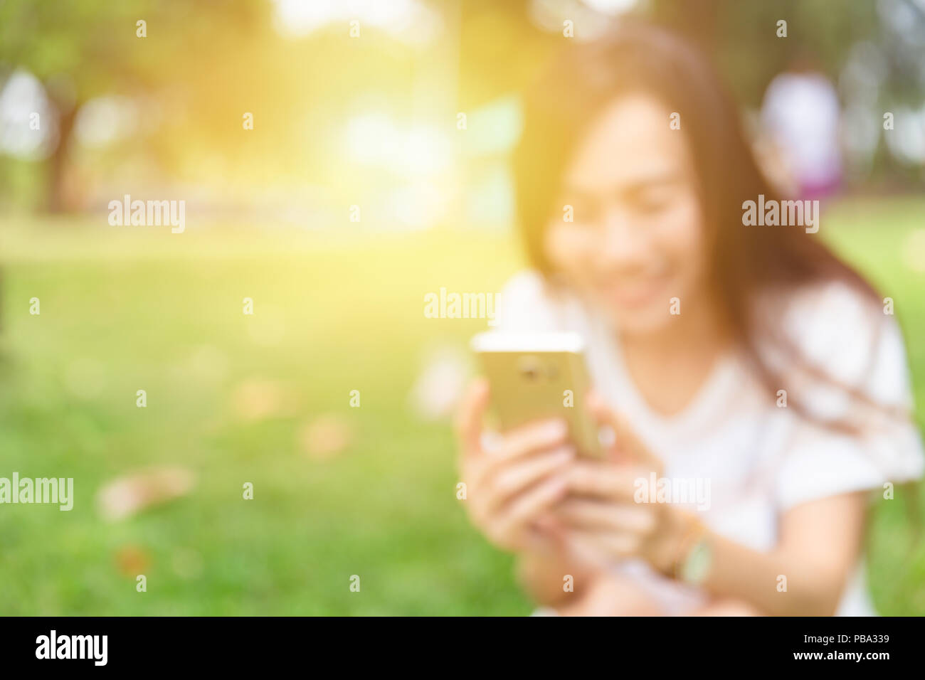 Blur girl teen using smartphone laugh and smile for background Stock Photo