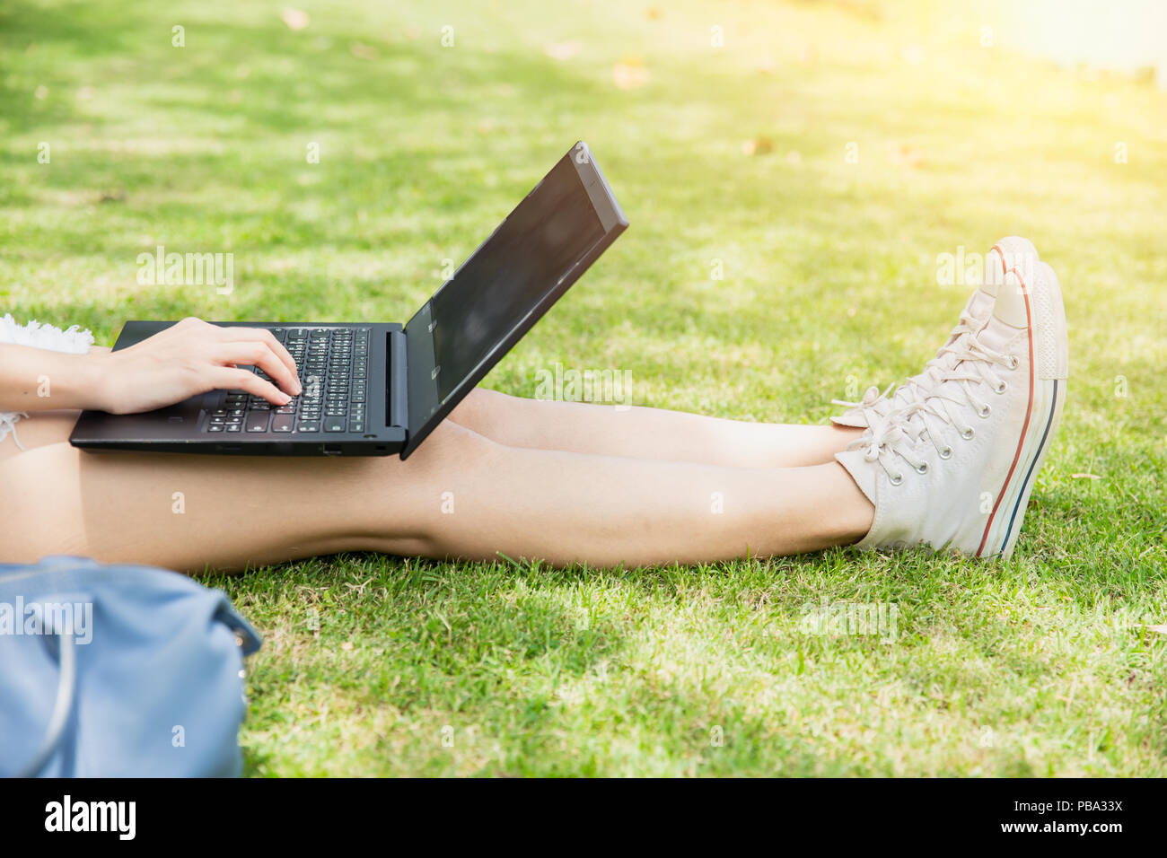 Teen student working with computer laptop outdoor university campus green park concept. Stock Photo