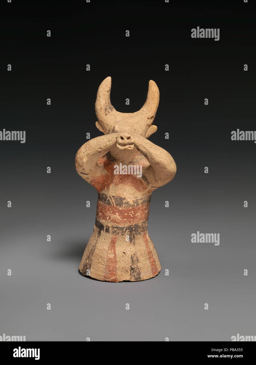 Terracotta figure wearing a bull mask. Culture: Cypriot. Dimensions: H. 5 1/8 in. (13.0 cm). Date: ca. 750-600 B.C..  The flaring cylindrical body is wheel-made and hollow. The upper part of the body and the head are handmade. Museum: Metropolitan Museum of Art, New York, USA. Stock Photo