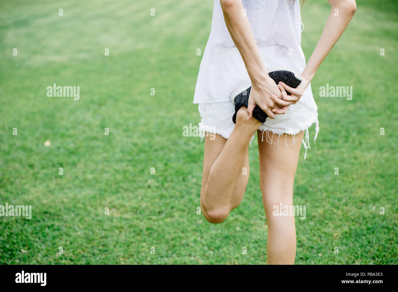 healthy slim girl leg stretching warm up before running or jogging