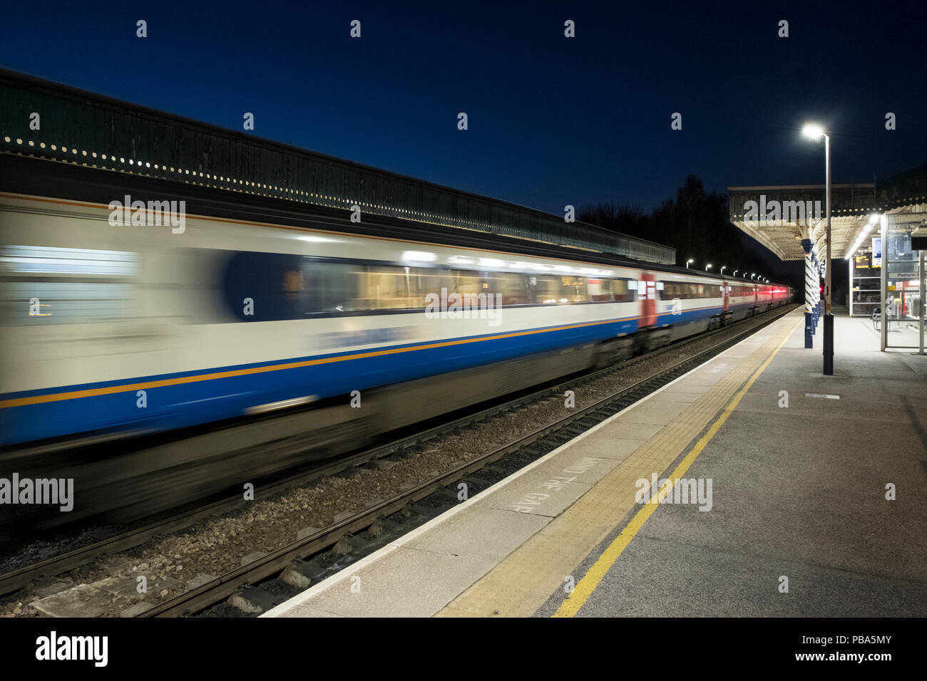 East Midlands Trains train leaving Chesterfield Railway Station at night, Chesterfield, Derbyshire, England, UK Stock Photo