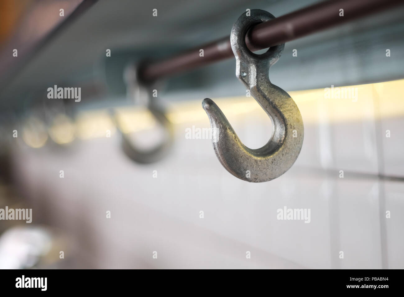 Row of cast iron hook for hanging bag under the counter bar top, selective focus. Stock Photo