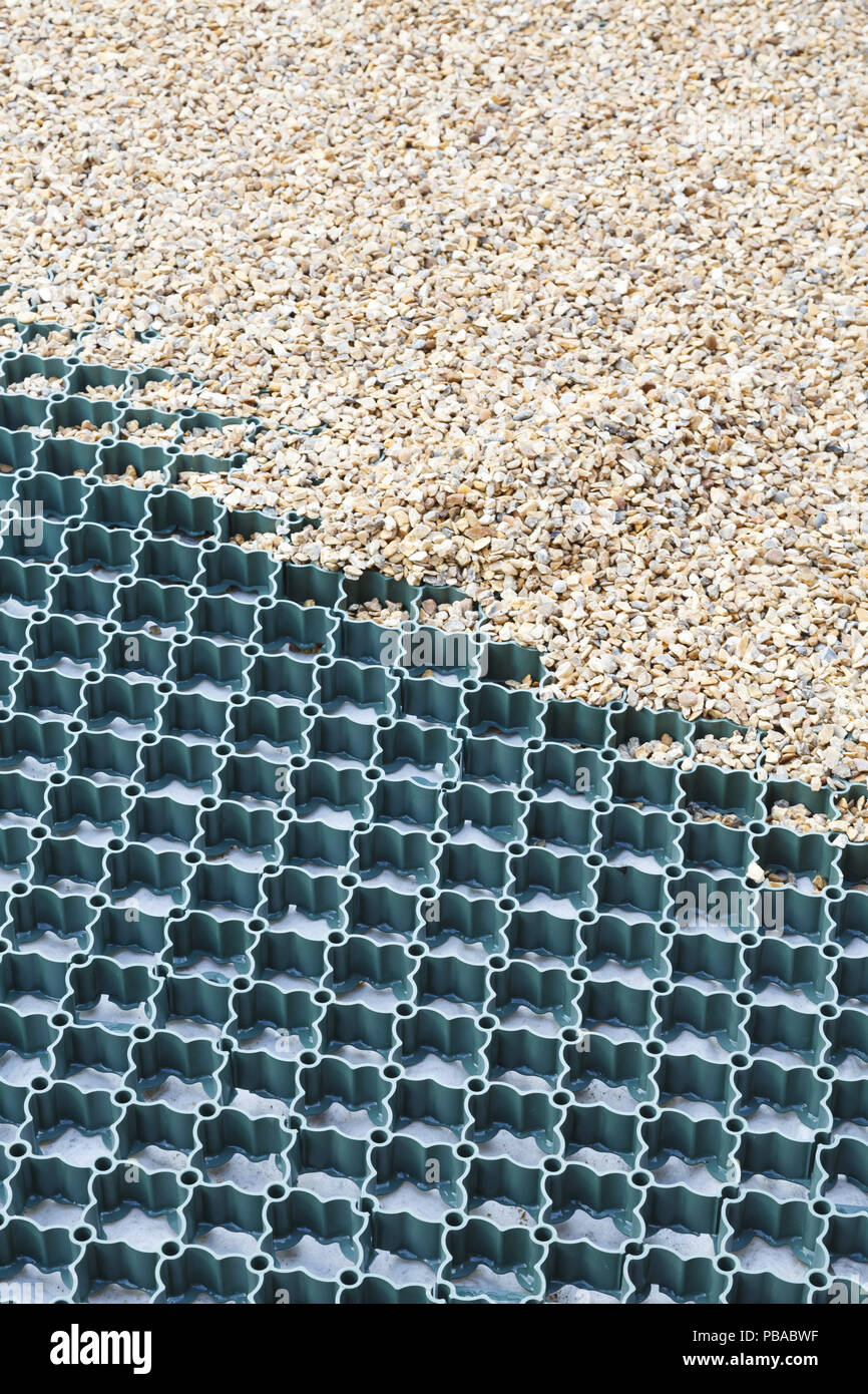 A plastic grid system installed to a gravel driveway protects the ground  and prevents the gravel from moving Stock Photo - Alamy