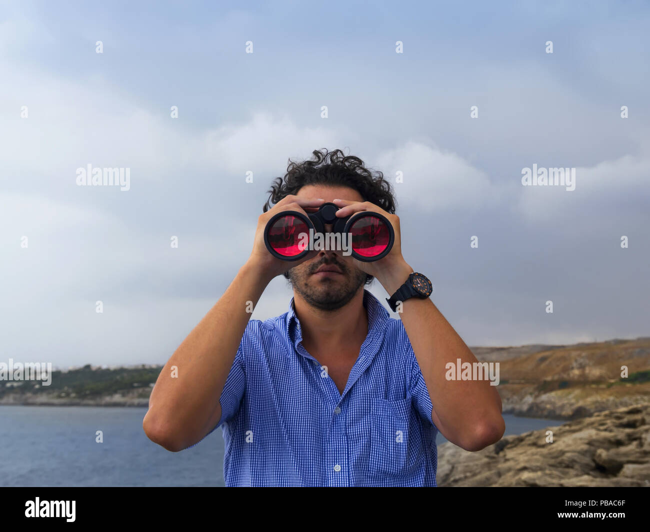 boy with binoculars scanned the horizon Stock Photo