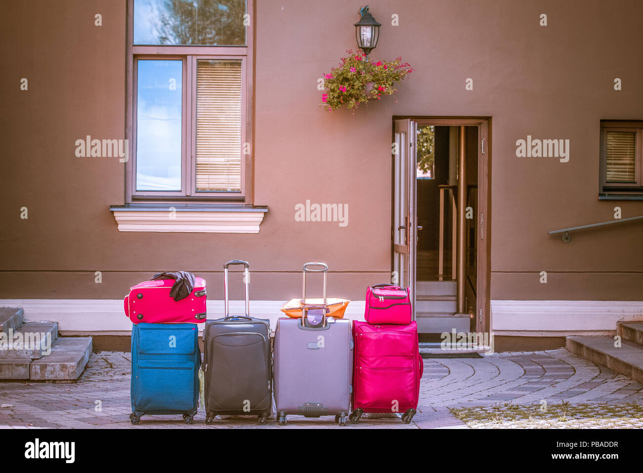 Colorful luggage suitcases near hotel outdoors. Stock Photo