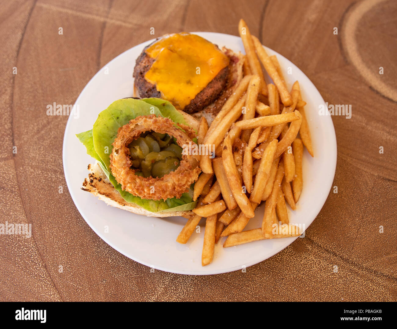 Cheeseburger With French Fries And Lettuce On White Plate Stock Photo
