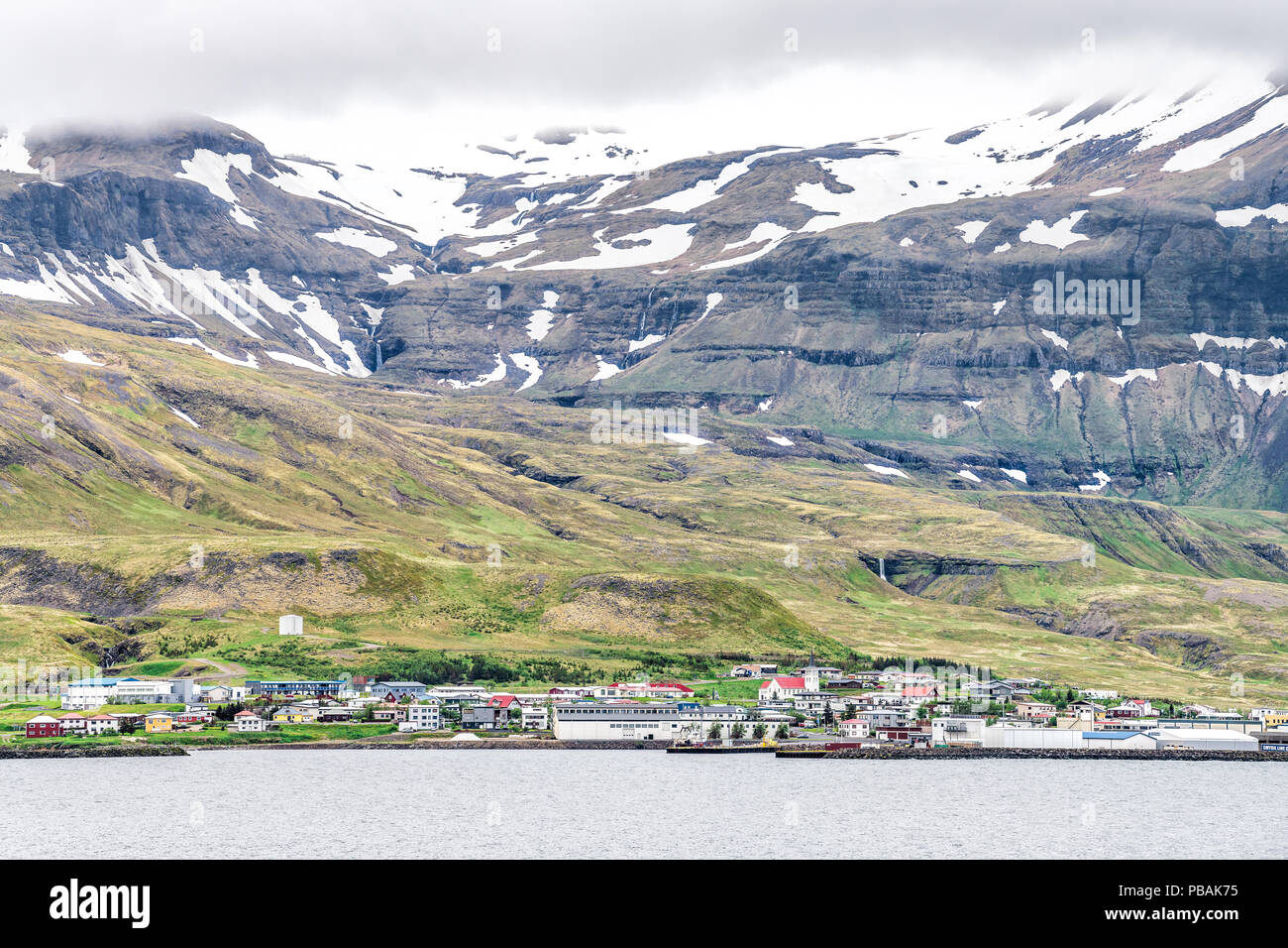 Overlook, cityscape skyline view on Grundarfjordur, Iceland, small town, fishing village with fjord, snow capped, covered mountains at foothill near K Stock Photo