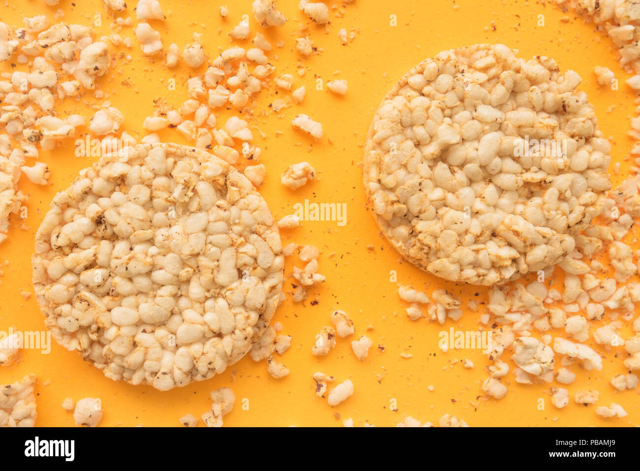 Flat lay crunchy rice cakes on yellow background, overhead top down view Stock Photo