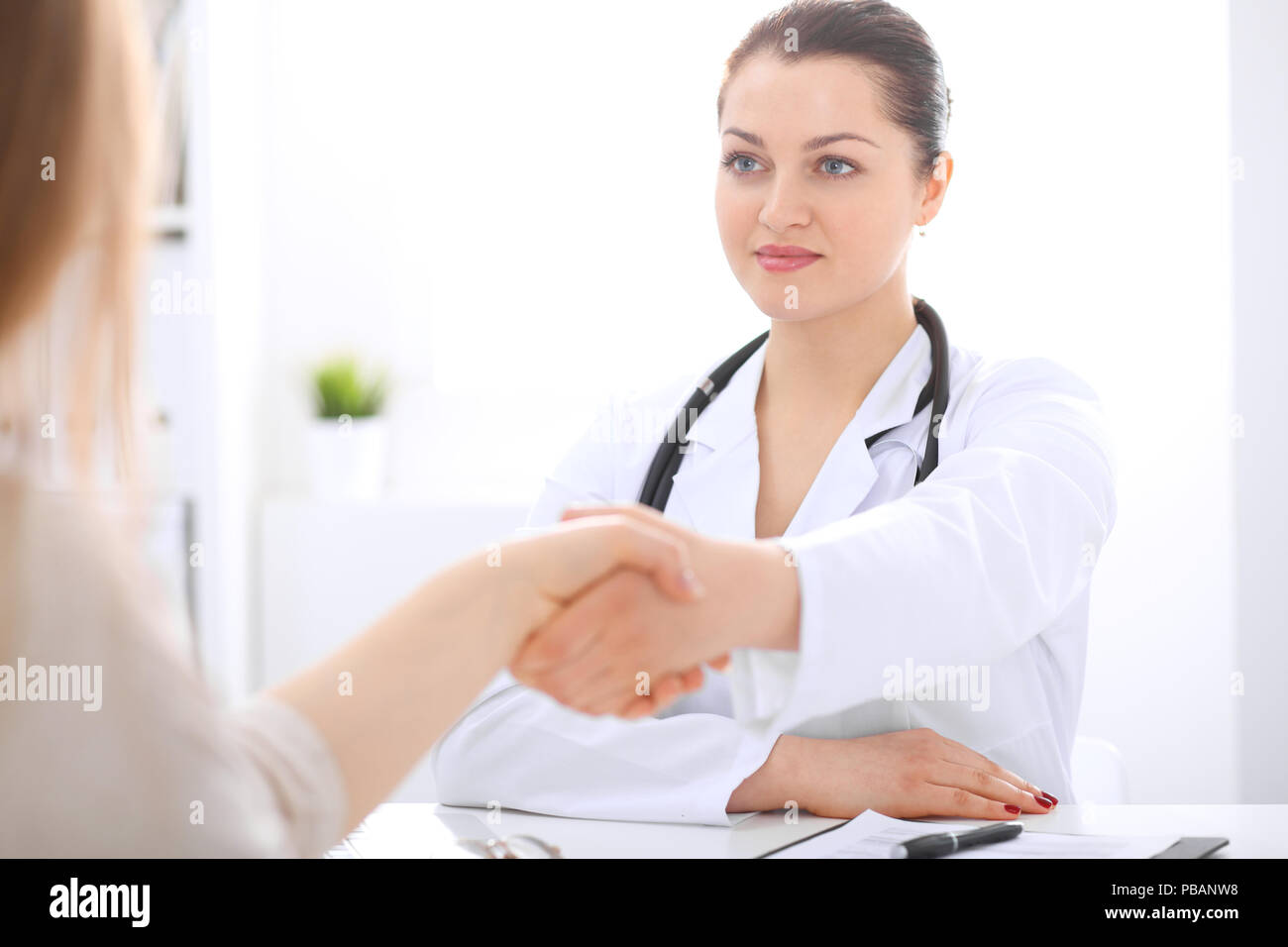 Trusting A Doctor Doctor and patient shaking hands to each other. Healthcare, medicine ...