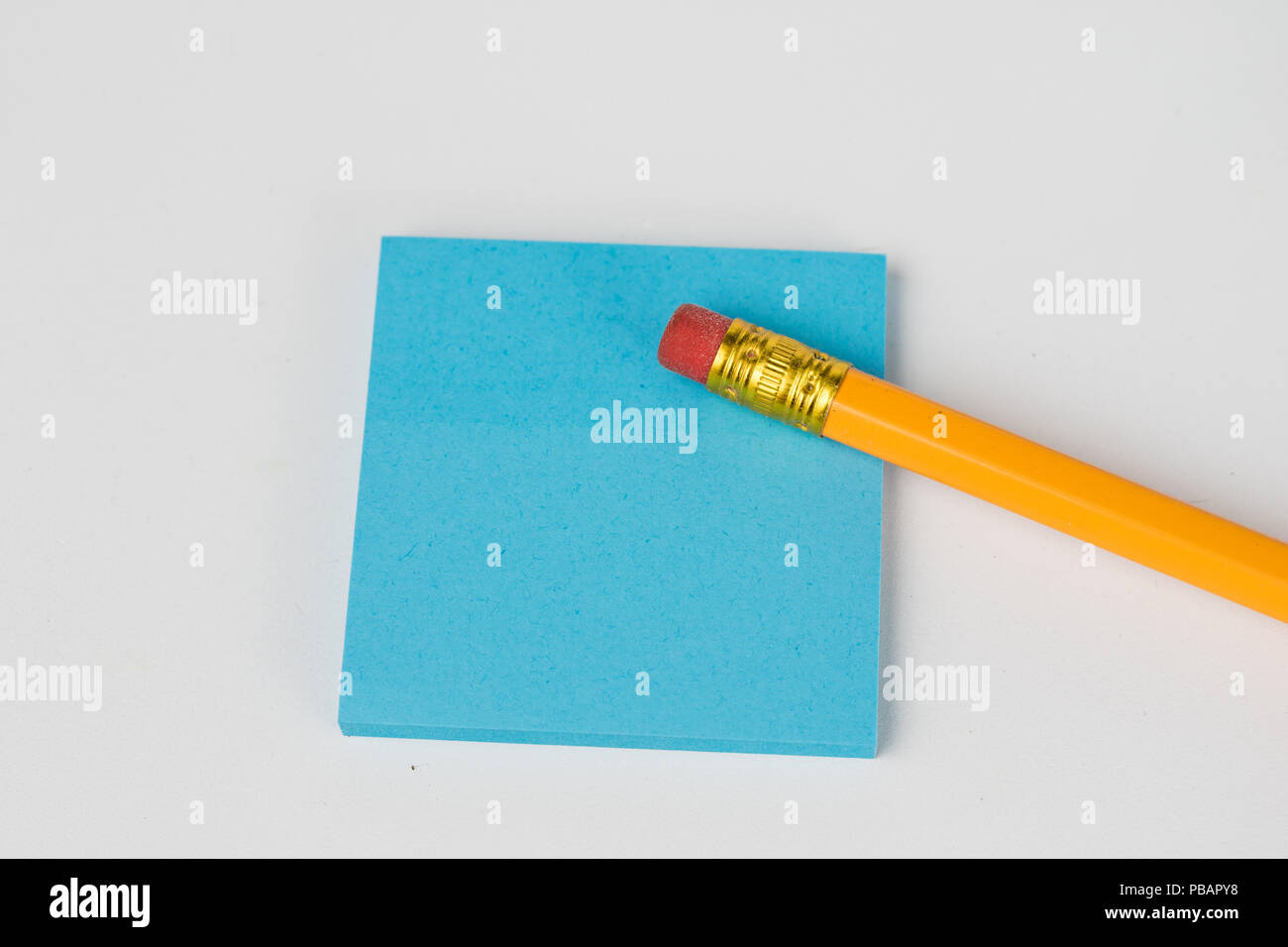 Pencil and sticky notes on a white table. Office accessories for saving notes. White background. Stock Photo