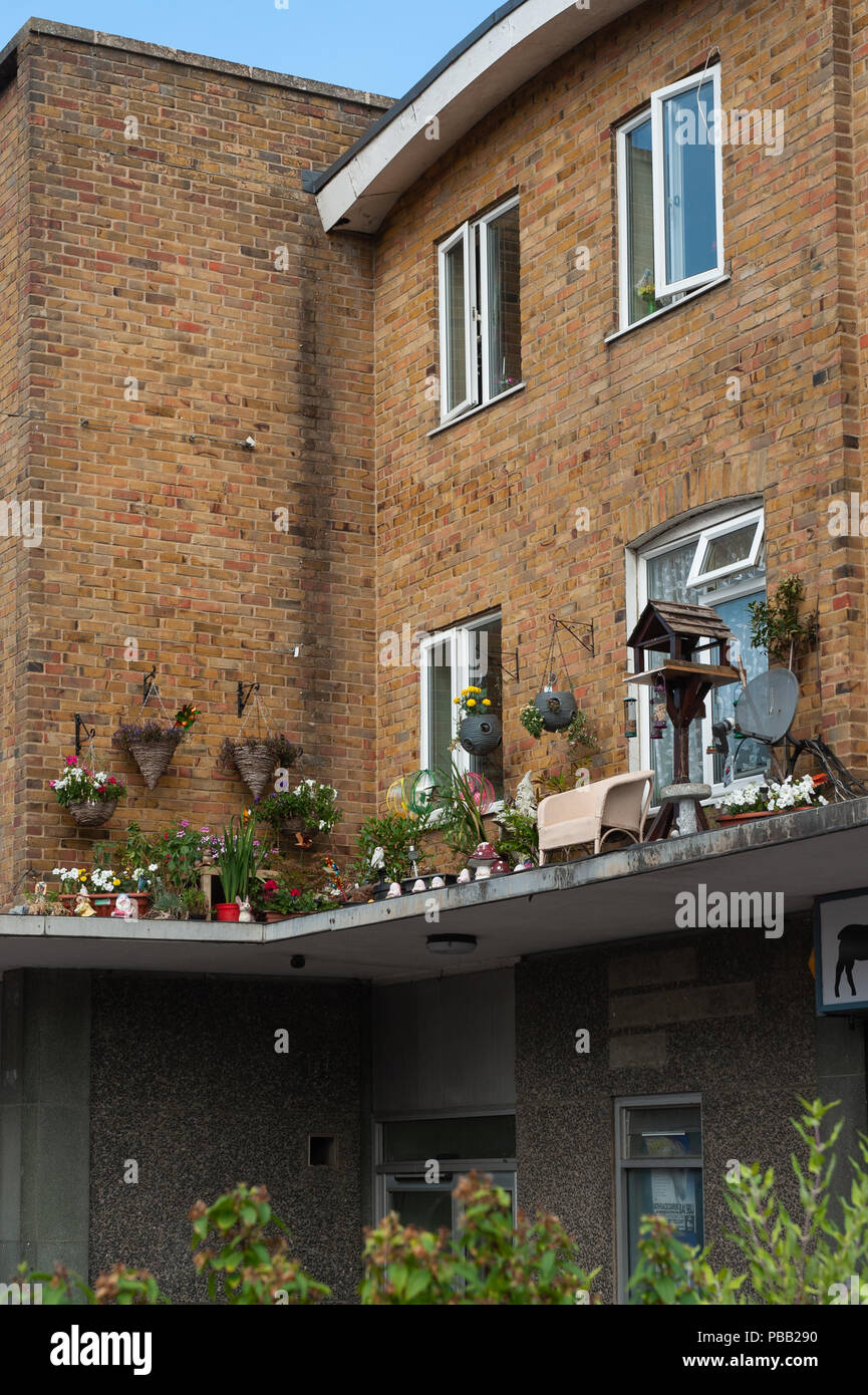 Concrete garden outside flat above shops with chair, plants and bird table. Stock Photo