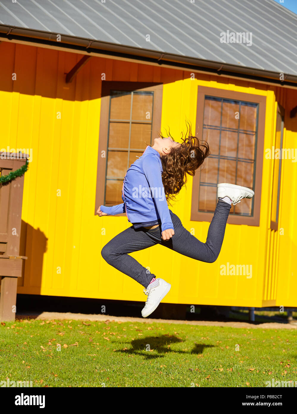 Teen girls in the park junping and having fun outdoors in sunny day Stock Photo