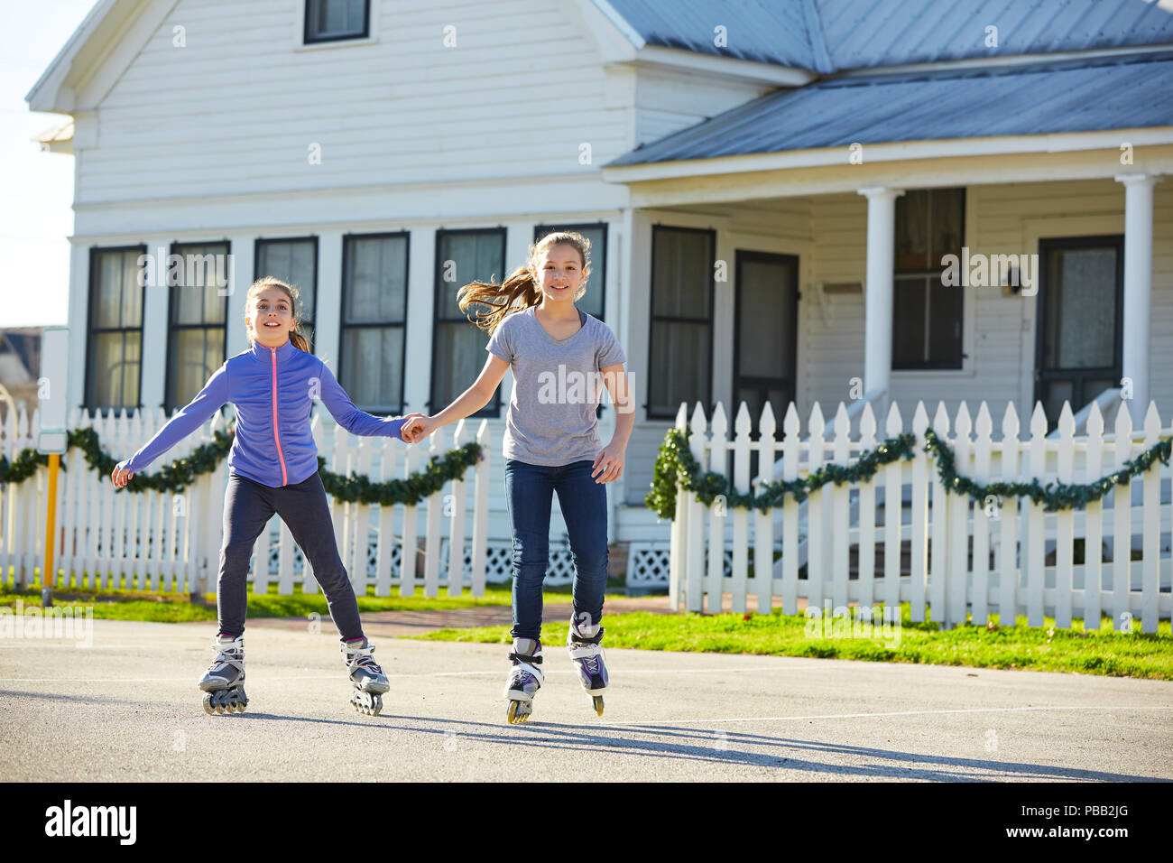 Teen girls group rolling skate in the street outdoor Stock Photo