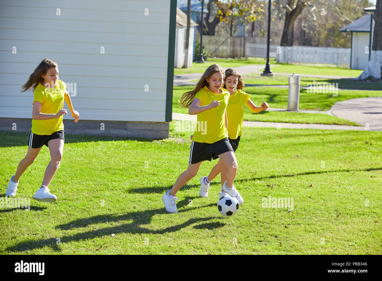 Friend girls teens playing football soccer in a park turf grass Stock Photo