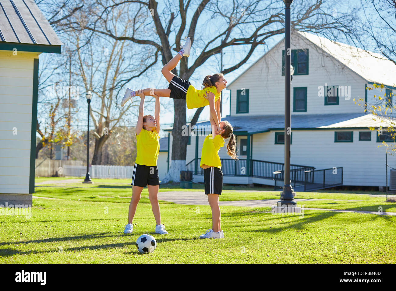Teen girls group exercise workout jump at park Stock Photo