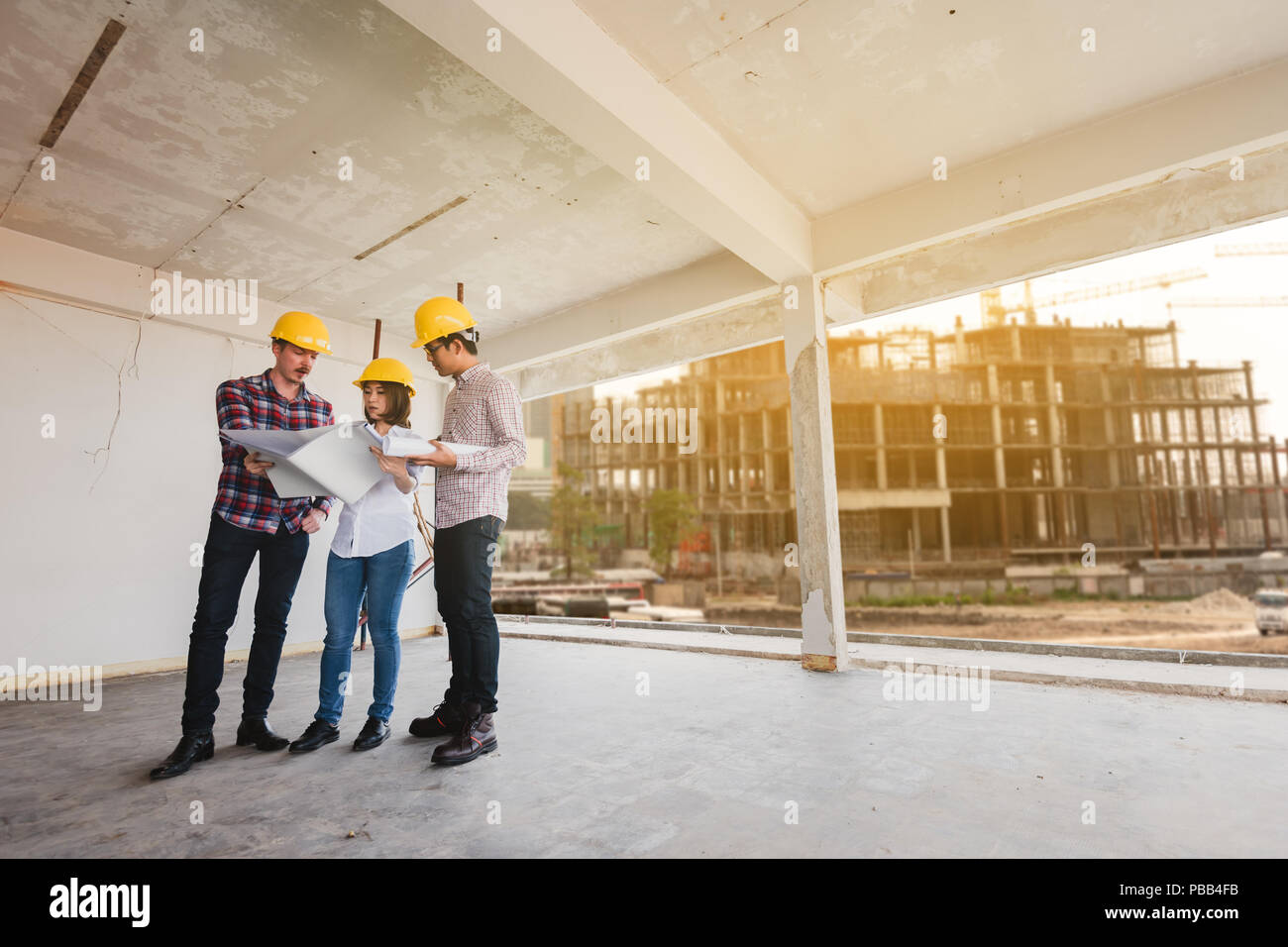 three construction engineers working together in construction site planning for the renovation Stock Photo
