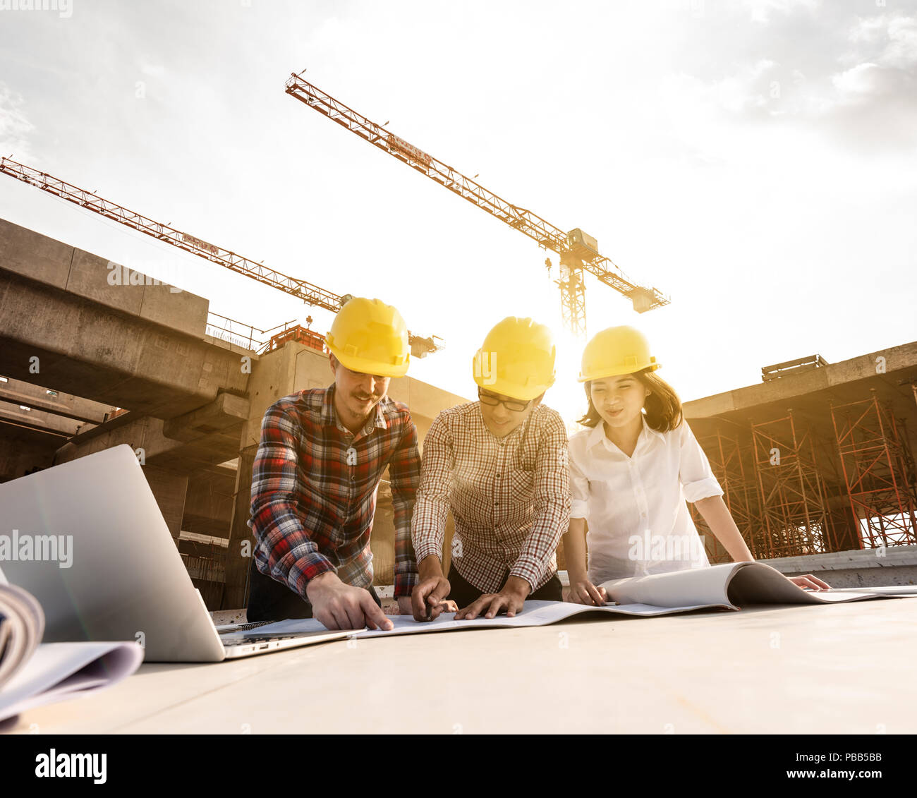 three construction engineers working together in construction site ...