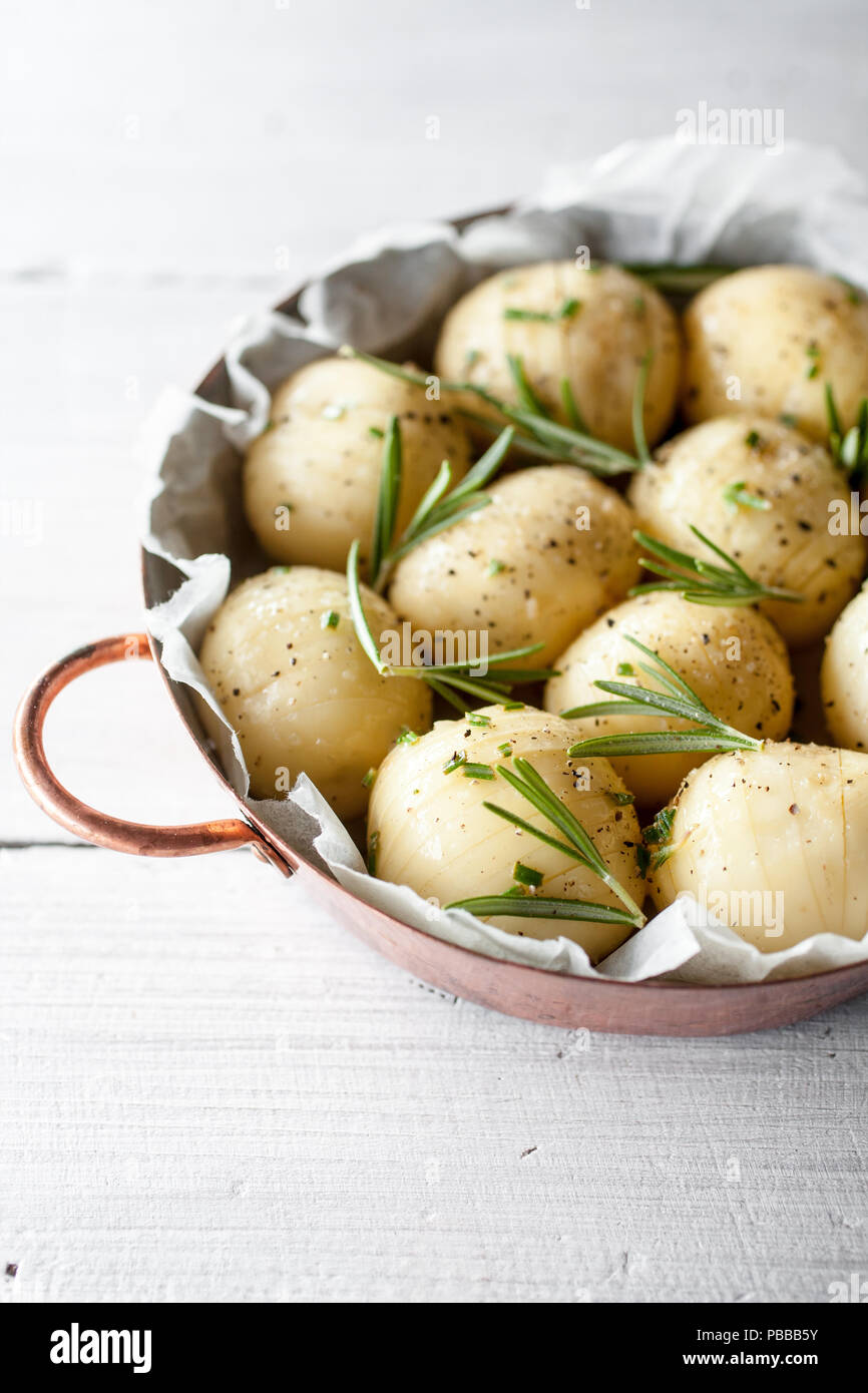 Lemony rosemary potatoes on white table Stock Photo