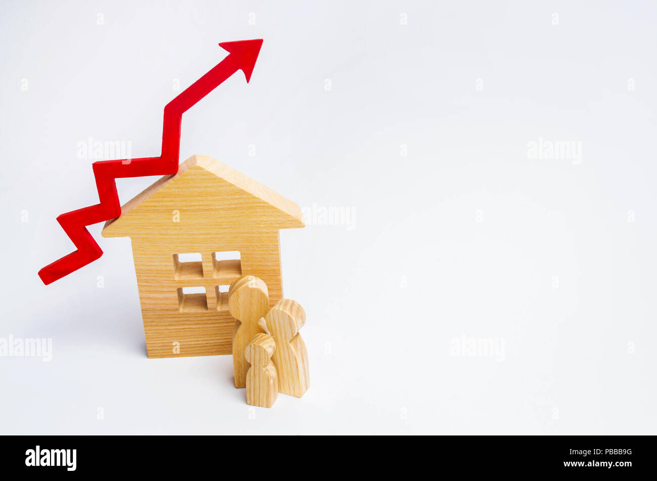 wooden house and family with a red arrow up. concept of high demand for real estate. increase energy efficiency of housing. rise in house prices. prop Stock Photo