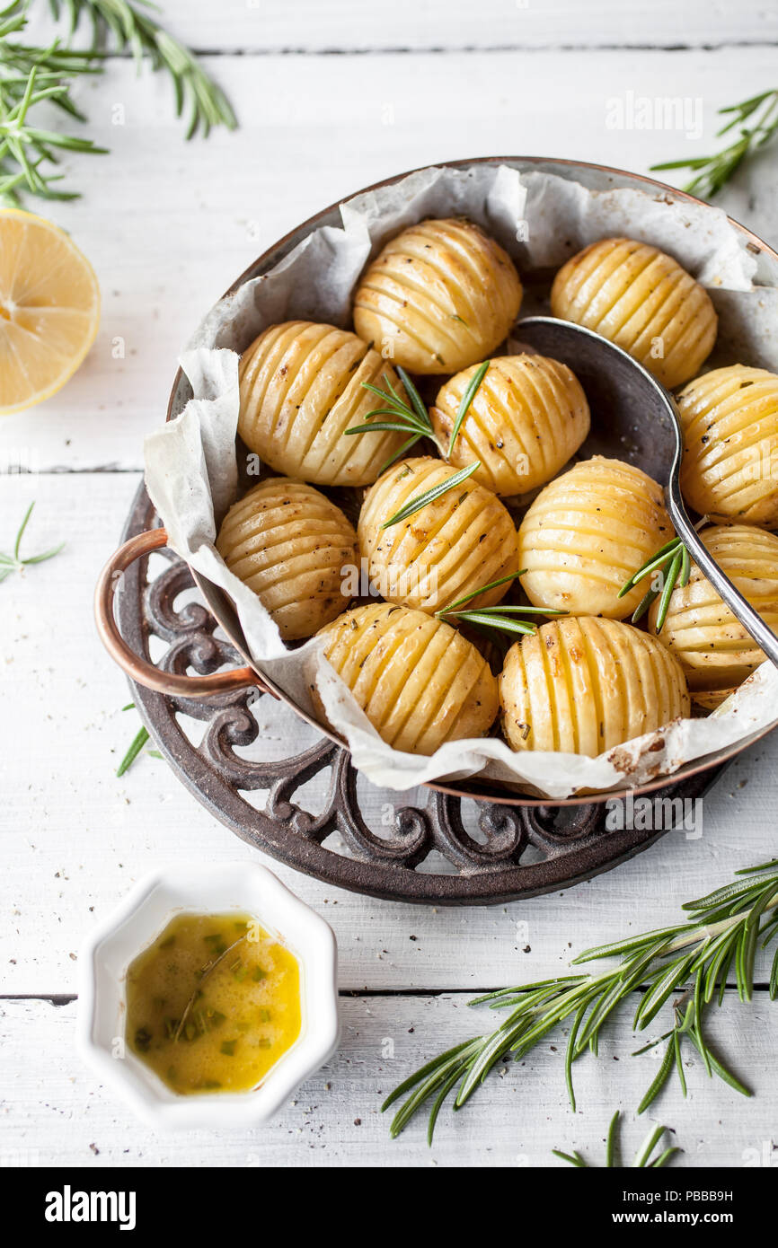 Lemony rosemary potatoes on white table Stock Photo