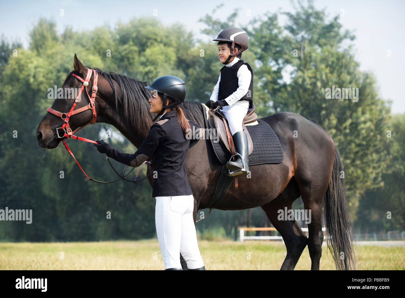 Young Chinese mother teaching daughter riding horse Stock Photo Alamy