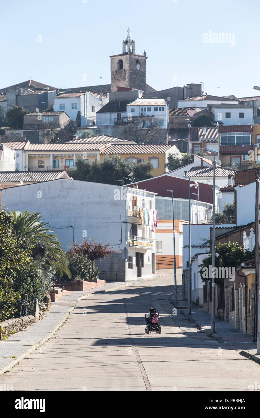 Person with disability crossing rural town with Motorized wheelchair, Extremadura, Spain Stock Photo