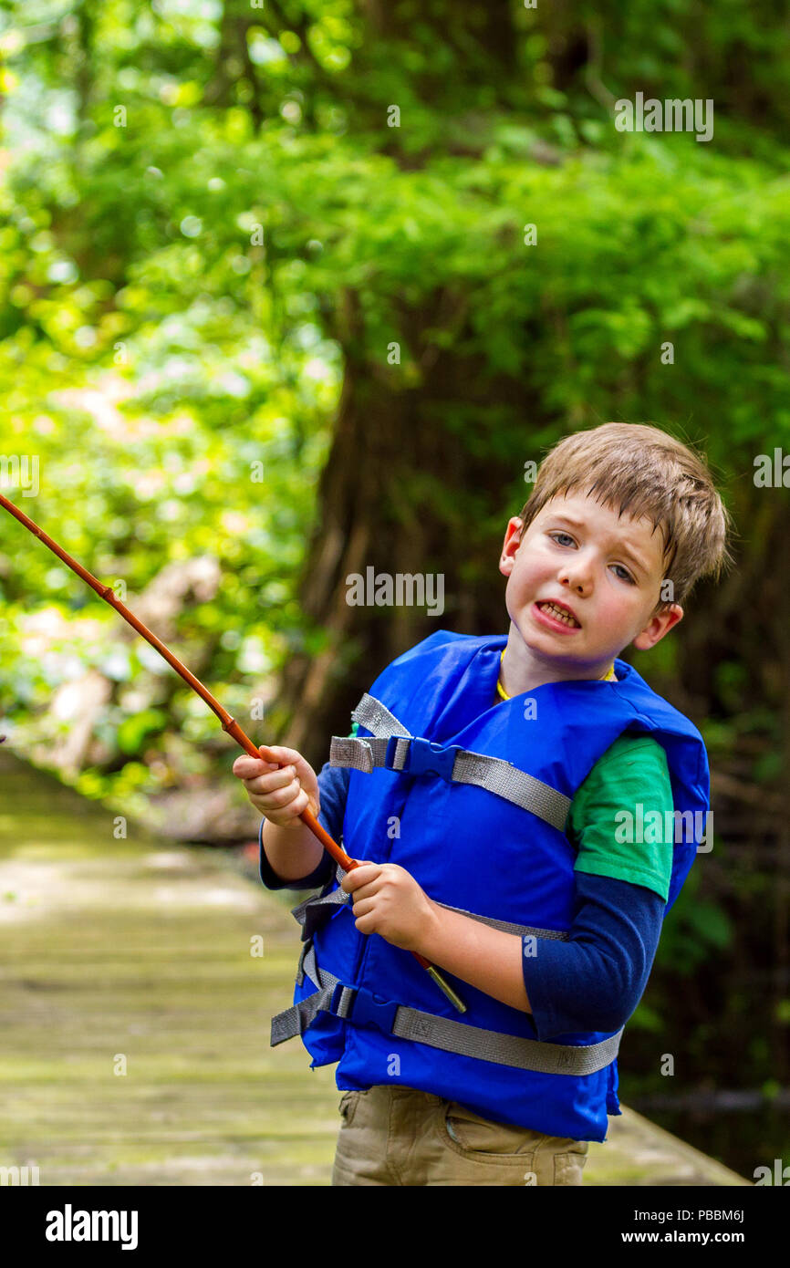 An exasperated little boy looks at the camera in frustration because his fishing  pole is caught in a tree. There is sweat dripping down the side of h Stock  Photo - Alamy
