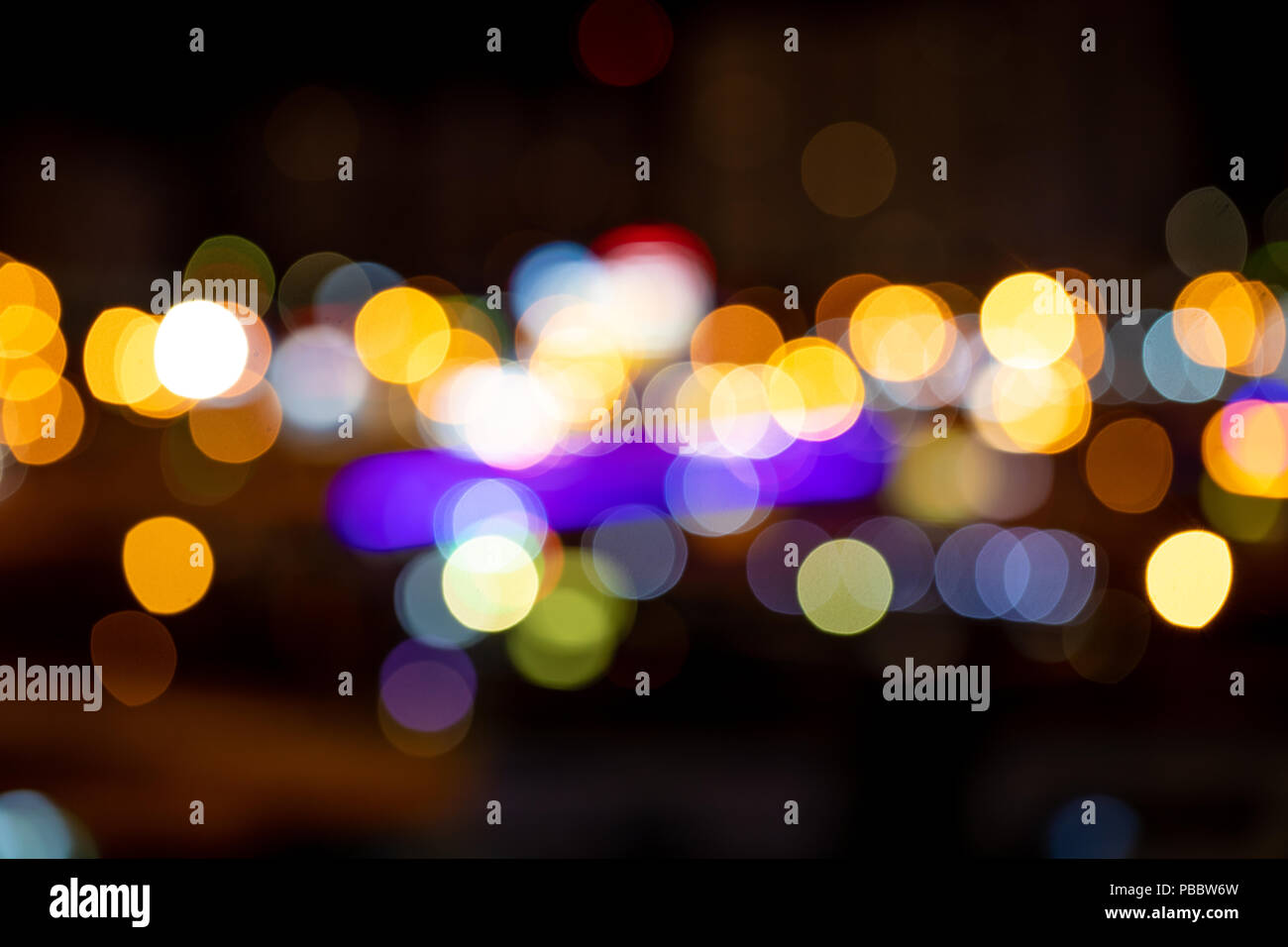Drops of night rain on window, on back plan washed away lights of the city Stock Photo