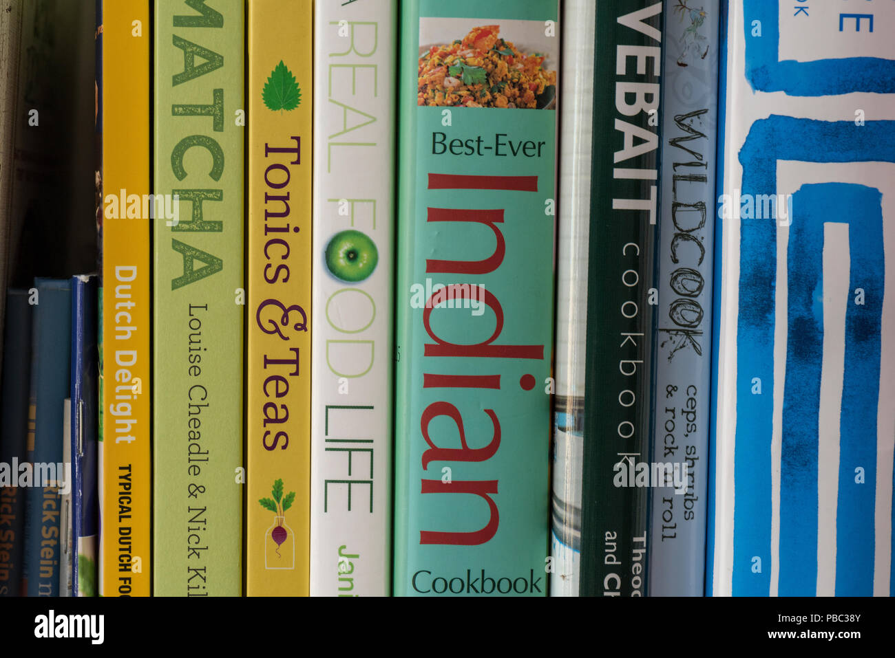 cookery books on cooking and recipes on a shelf. colourful recipes books. Stock Photo