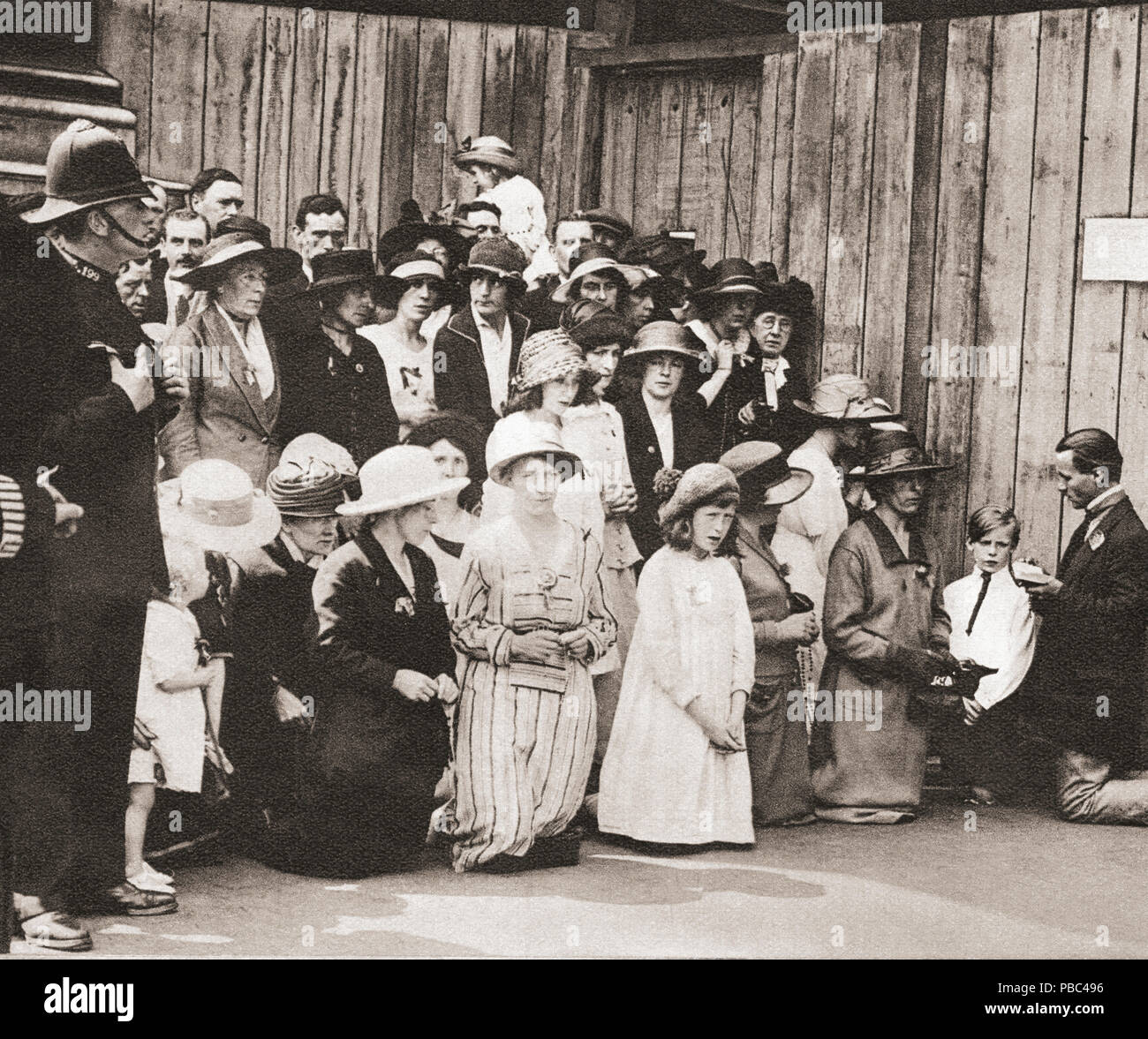 Irish men, women and children on their knees praying in Downing Street during the Anglo-Irish Treaty meetings of 1921.   The Anglo-Irish Treaty aka The Treaty, was an agreement between the government of the United Kingdom of Great Britain and Ireland and representatives of the Irish Republic that ended the Irish War of Independence and provided for the establishment of the Irish Free State.  From These Tremendous Years, published 1938. Stock Photo