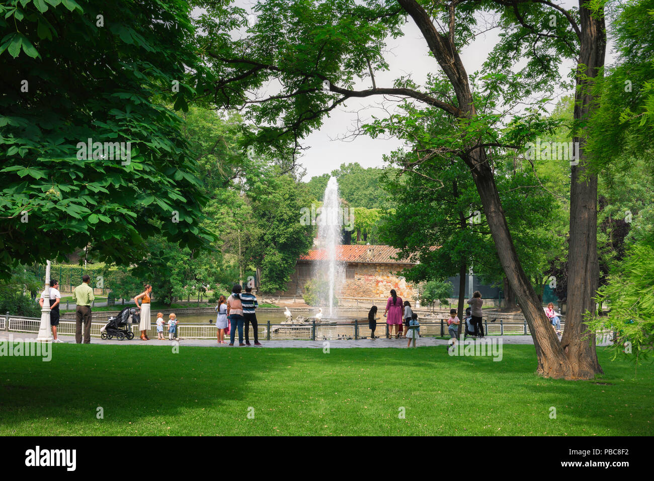 Bilbao park Spain, view of adults and children standing beside a lake in the center of the Parque de Dona Casilda d'Iturriza in Bilbao, Spain. Stock Photo
