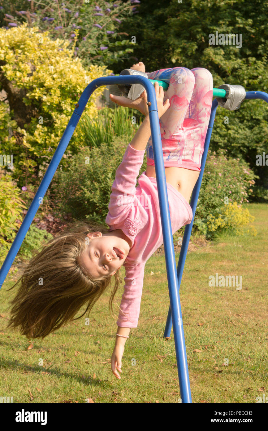 six year old girl doing gymnastics acrobatics on apparatus in back