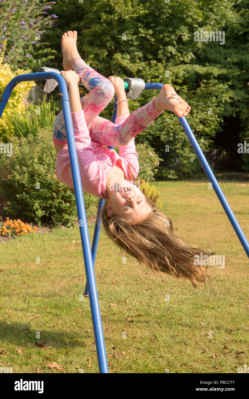 six year old girl doing gymnastics acrobatics on apparatus in back