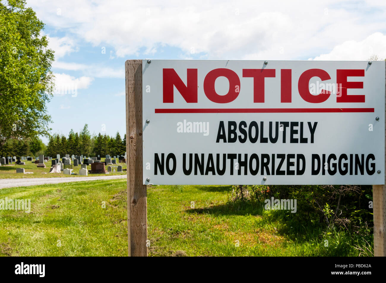 An unusual sign at a Canadian cemetery reads Absolutely No Unauthorized Digging. Stock Photo