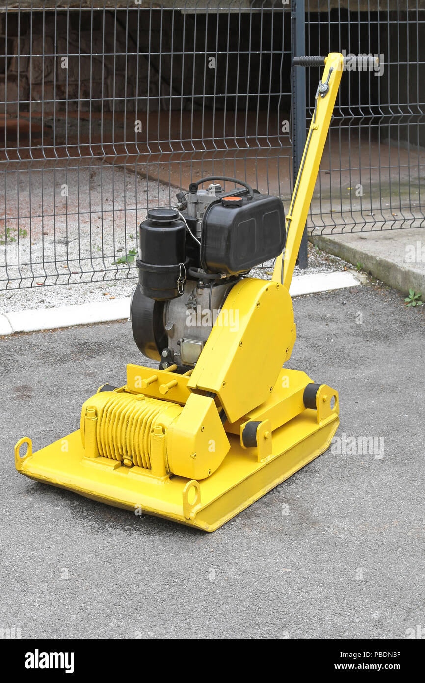 Yellow vibratory plate compactor at construction site Stock Photo Alamy