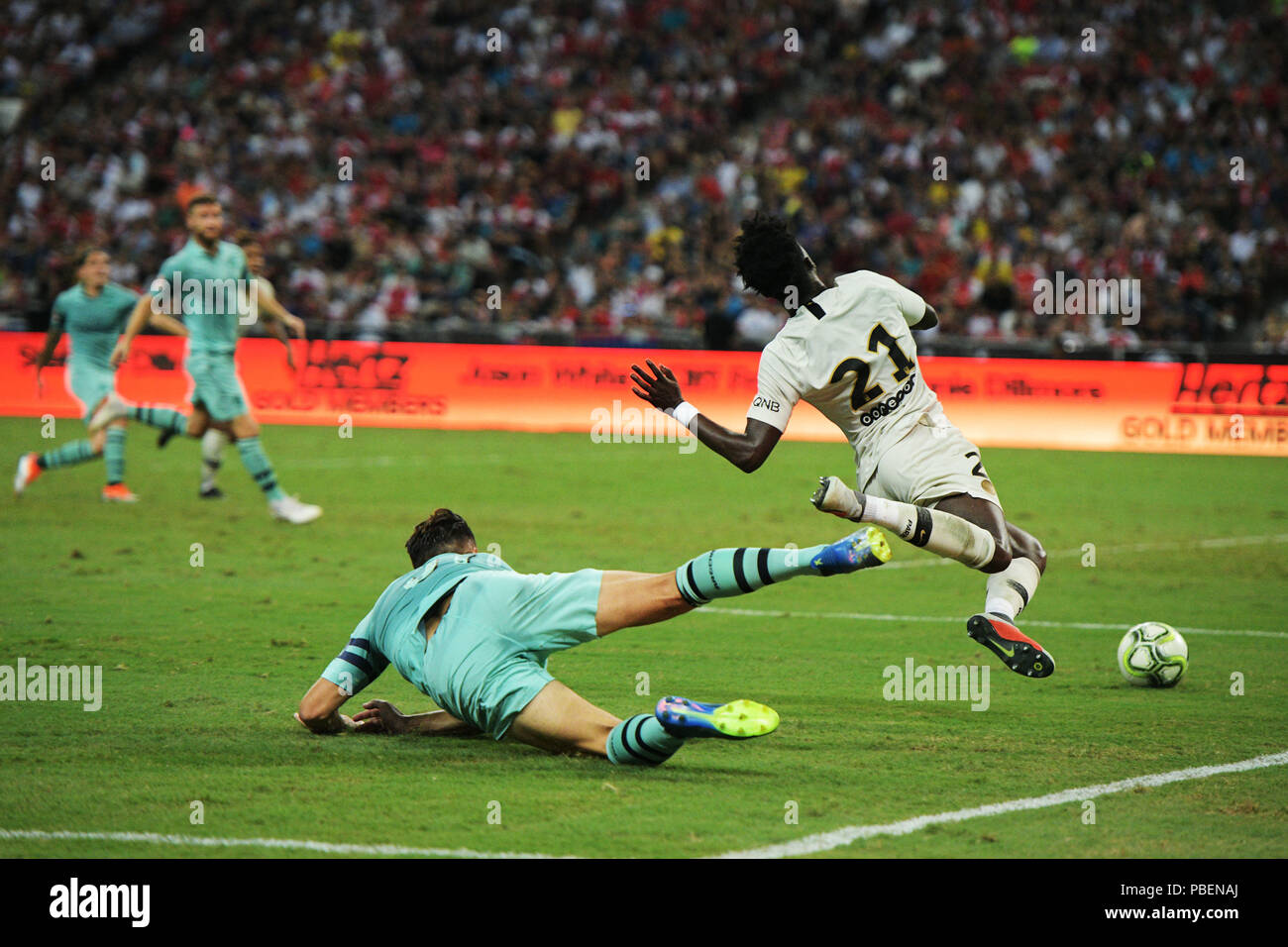 Singapore. 28th July, 2018. Arsenal's Sead Kolasinac (front L) tackles Paris Saint-Germain's Timothy Weah down during the International Champions Cup soccer match held in Singapore on July 28, 2018. Credit: Then Chih Wey/Xinhua/Alamy Live News Stock Photo