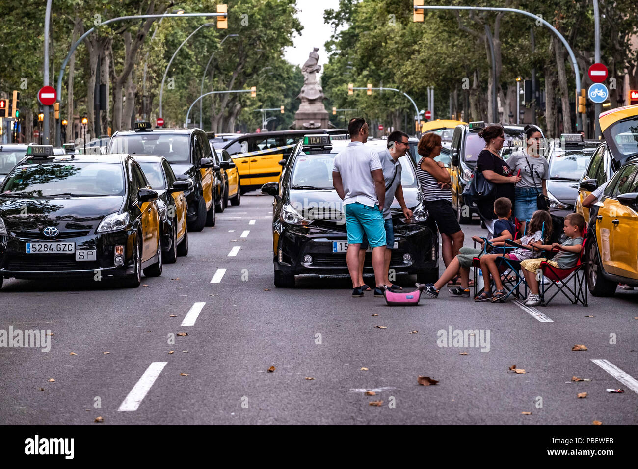 Barcelona, Catalonia, Spain. 28th July, 2018. A group of taxi drivers with their families organize themselves to spend a night in their vehicles.Taxi drivers strike indefinitely and hundreds of taxis are parked along the Gran VÃ-a de Barcelona. The taxi drivers plan to keep the strike until the Government of Spain approves next Friday a decree Law with the modifications claimed. Credit: Paco Freire/SOPA Images/ZUMA Wire/Alamy Live News Stock Photo