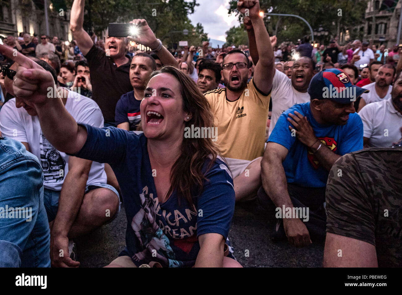Barcelona, Catalonia, Spain. 28th July, 2018. A group of taxi drivers are seen shouting slogans during the assembly.Taxi drivers strike indefinitely and hundreds of taxis are parked along the Gran VÃ-a de Barcelona. The taxi drivers plan to keep the strike until the Government of Spain approves next Friday a decree Law with the modifications claimed. Credit: Paco Freire/SOPA Images/ZUMA Wire/Alamy Live News Stock Photo