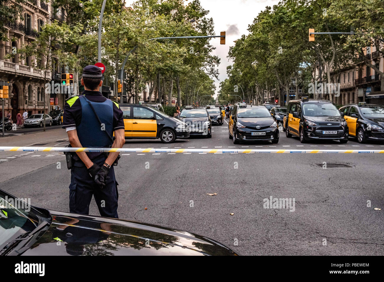 Barcelona, Catalonia, Spain. 28th July, 2018. An urban guard is seen ordering traffic during the taxi drivers strike.Taxi drivers strike indefinitely and hundreds of taxis are parked along the Gran VÃ-a de Barcelona. The taxi drivers plan to keep the strike until the Government of Spain approves next Friday a decree Law with the modifications claimed. Credit: Paco Freire/SOPA Images/ZUMA Wire/Alamy Live News Stock Photo