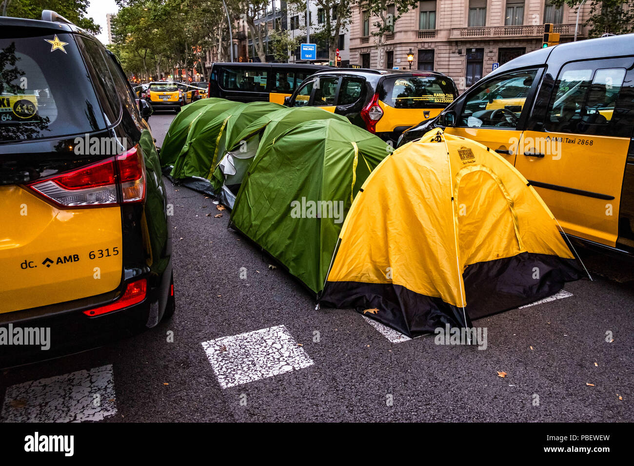 Barcelona, Catalonia, Spain. 28th July, 2018. Several tents used by drivers are seen between taxis.Taxi drivers strike indefinitely and hundreds of taxis are parked along the Gran VÃ-a de Barcelona. The taxi drivers plan to keep the strike until the Government of Spain approves next Friday a decree Law with the modifications claimed. Credit: Paco Freire/SOPA Images/ZUMA Wire/Alamy Live News Stock Photo