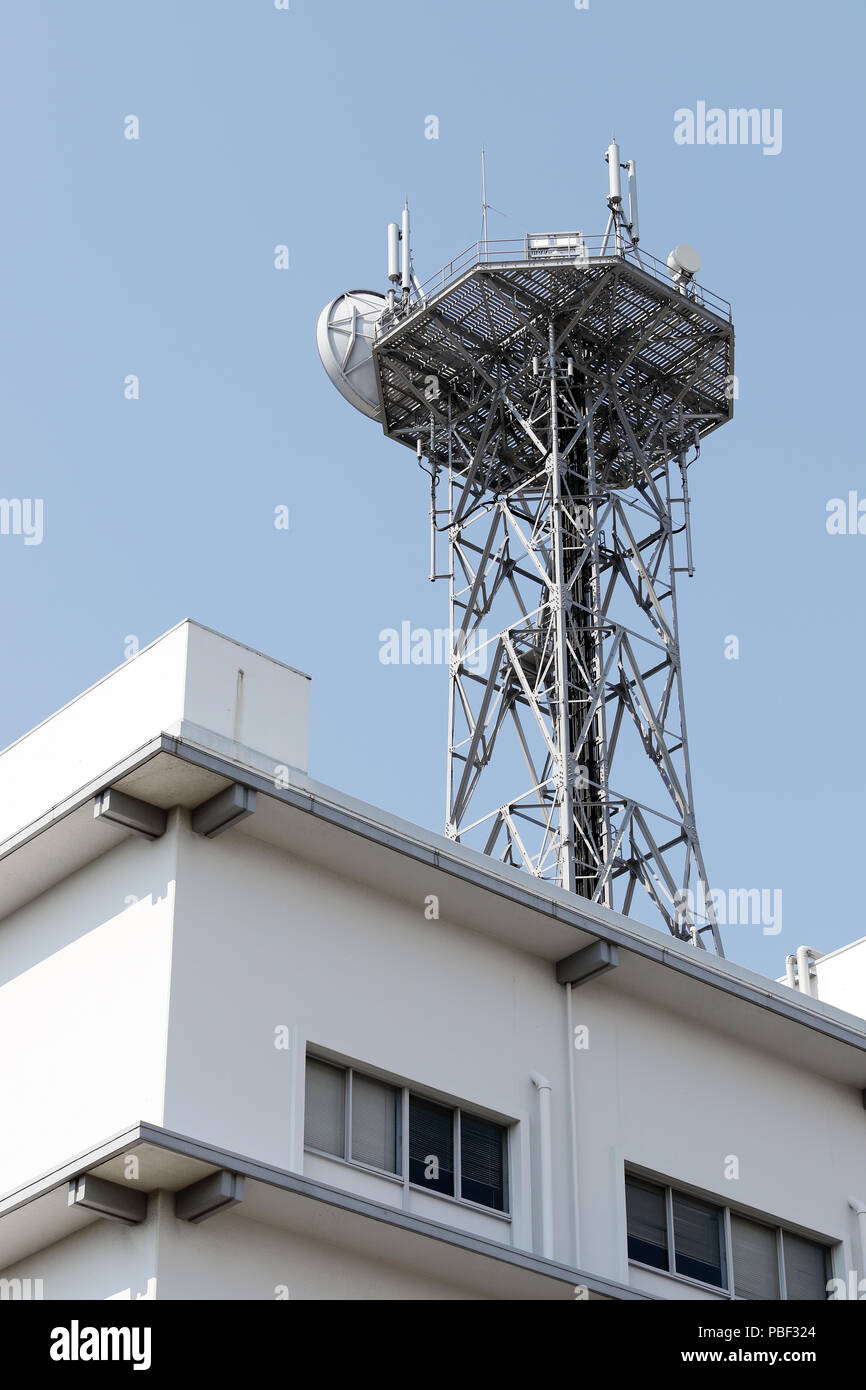 View of communications tower with antennas against blue sky Stock Photo
