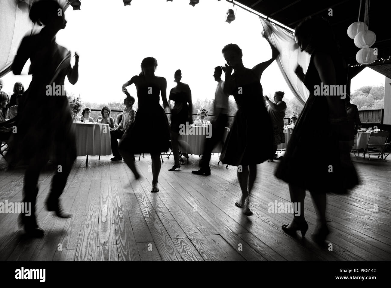 Ladies dancing in an open barn at a mountain wedding reception. Stock Photo