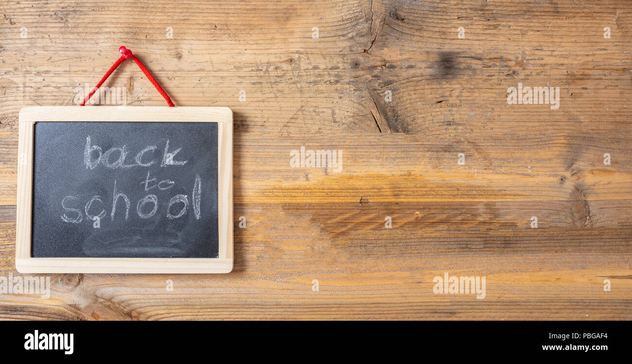 Back to school drawing on blackboard with frame hanging on wooden wall, banner, copy space Stock Photo
