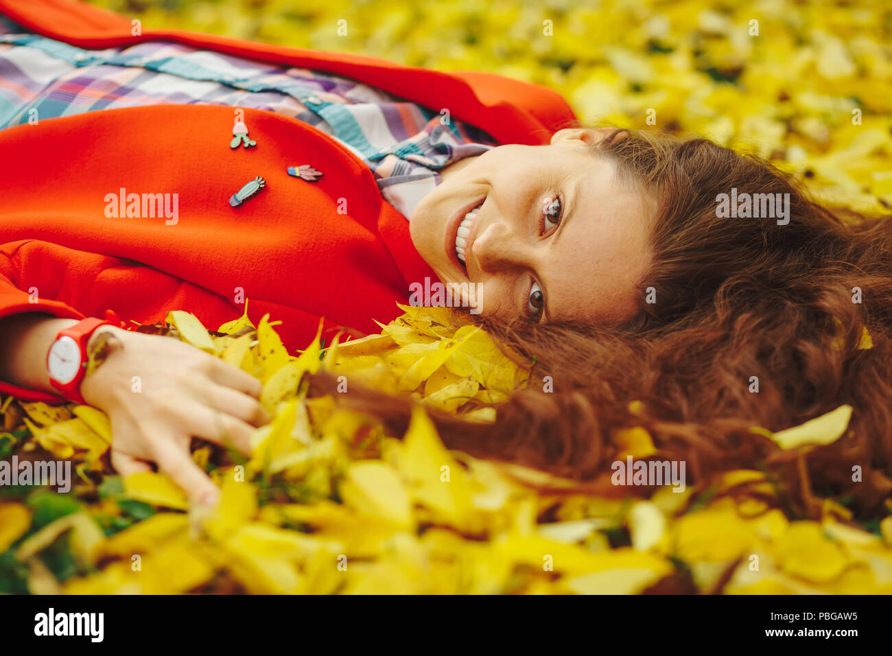 Young beautiful lady surrounded autumn leaves Stock Photo