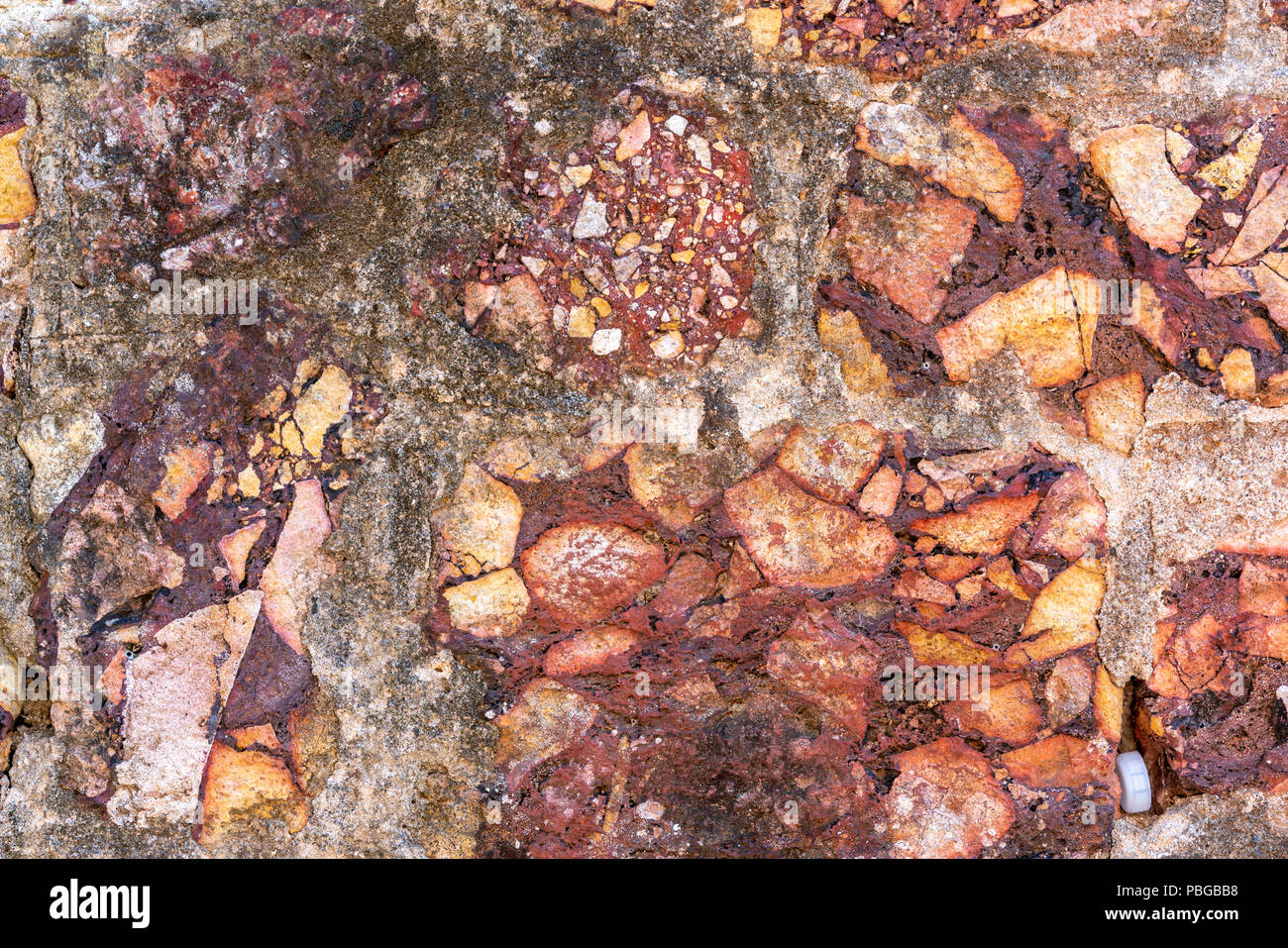 Cemented naural flint rough dirty red stone wall background Stock Photo