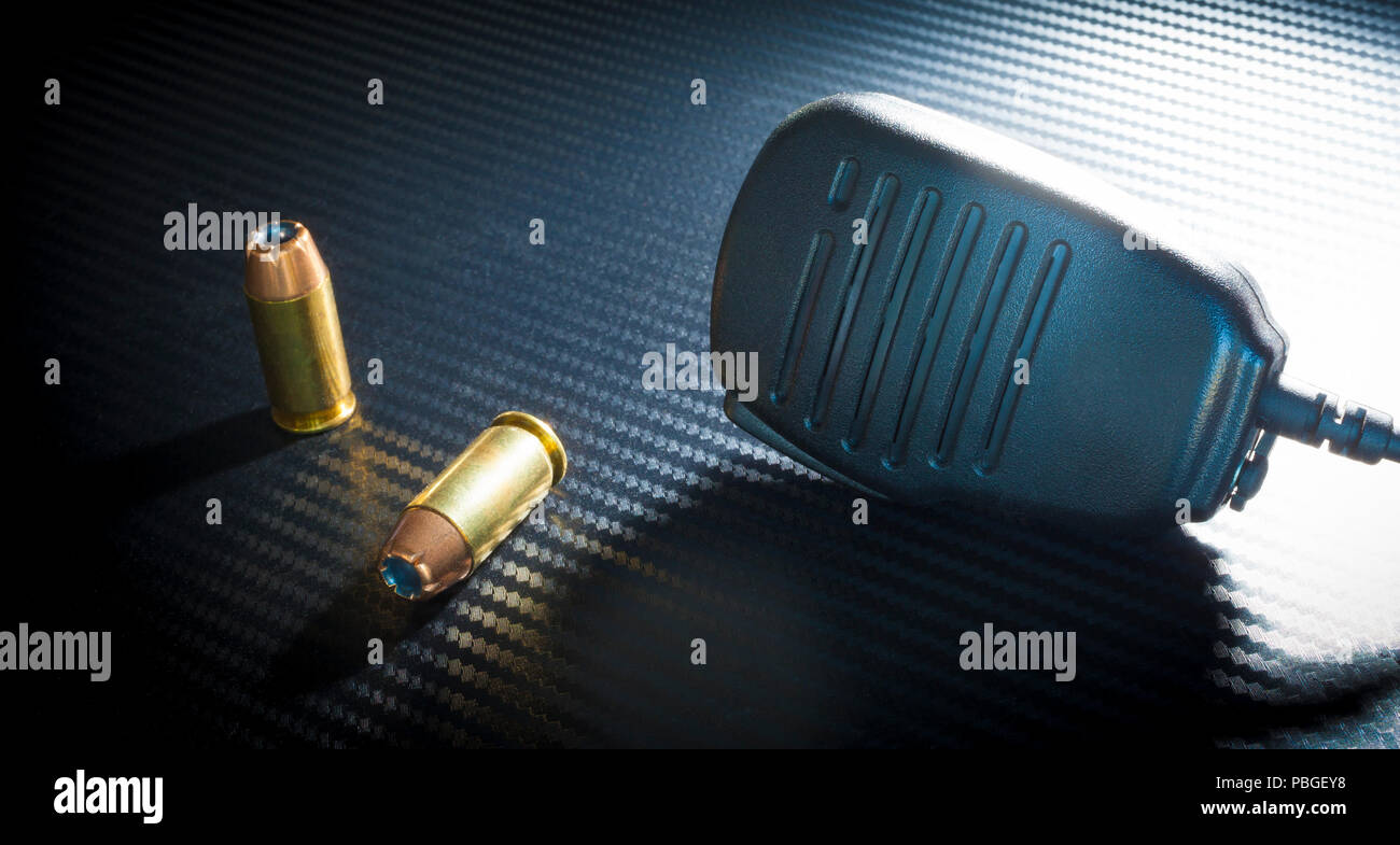 Police radio style microphone and a pair of handgun bullets Stock Photo