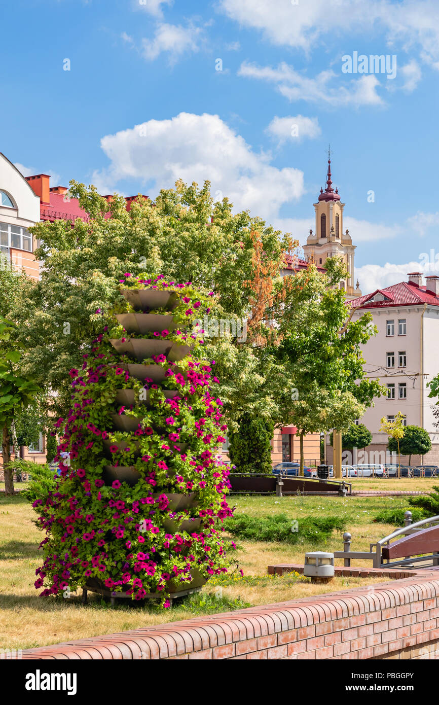 Empty City landscape with decorative flower beds overlooking Catholic church of the Discovery of the Holy Cross (Bernardine) in Grodno, Belarus Stock Photo